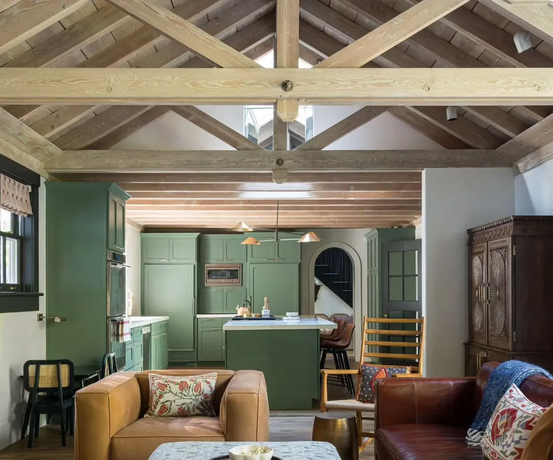 In this San Francisco home, we opened up the living area to the kitchen, creating a seamless flow for family life. The exposed wooden beams on the vaulted ceiling add rustic warmth, contrasting with the clean lines of the olive green kitchen cabinetry. It’s a space designed for connection, where cooking, conversation, and relaxation happen all at once.
