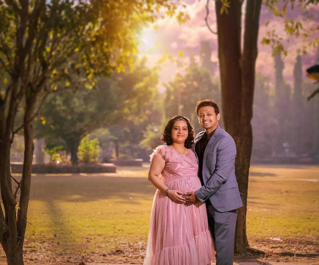An outdoor maternity session for an expecting couple, using the beautiful golden hour light in a park setting. This style is perfect for capturing the warmth and anticipation of your journey to parenthood.
