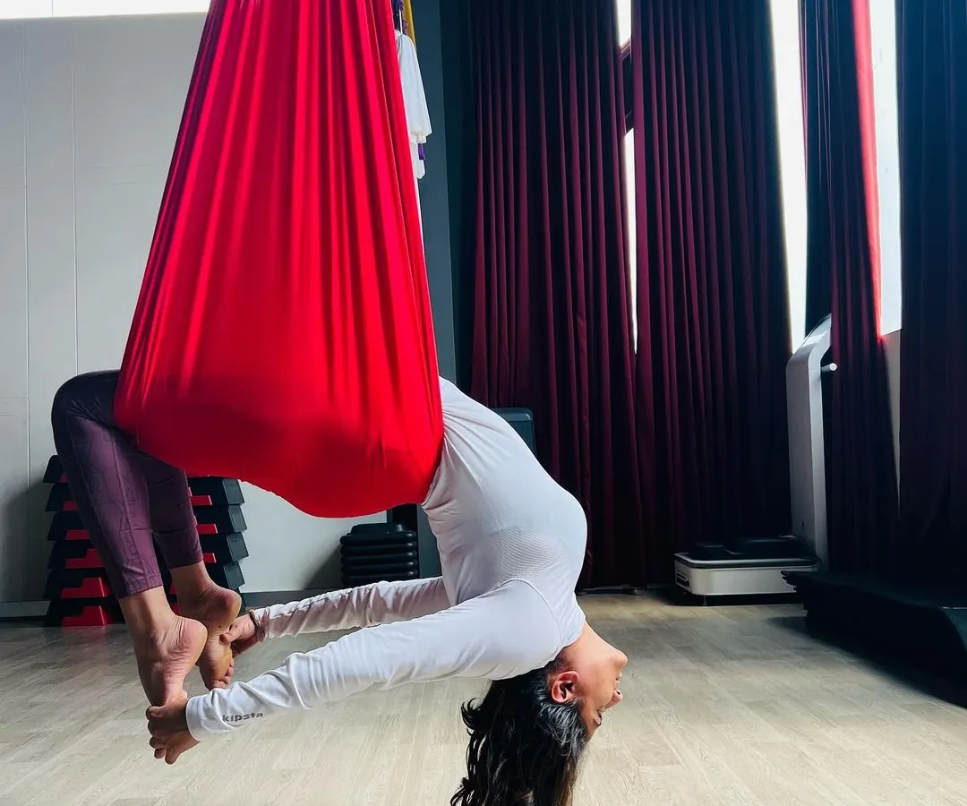 I believe life is better when you let go and allow yourself to evolve, one day at a time... This beautiful inversion, supported by the soft red hammock, is more than just a pose. It's a moment of trust and release that helps decompress the spine and open the heart. ❤️