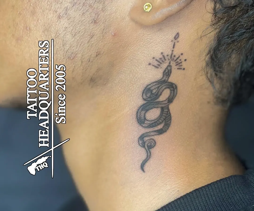 A classic gold stud in the earlobe. This client also got a fine-line snake tattoo on their neck, showcasing how we can help you combine different forms of body art.