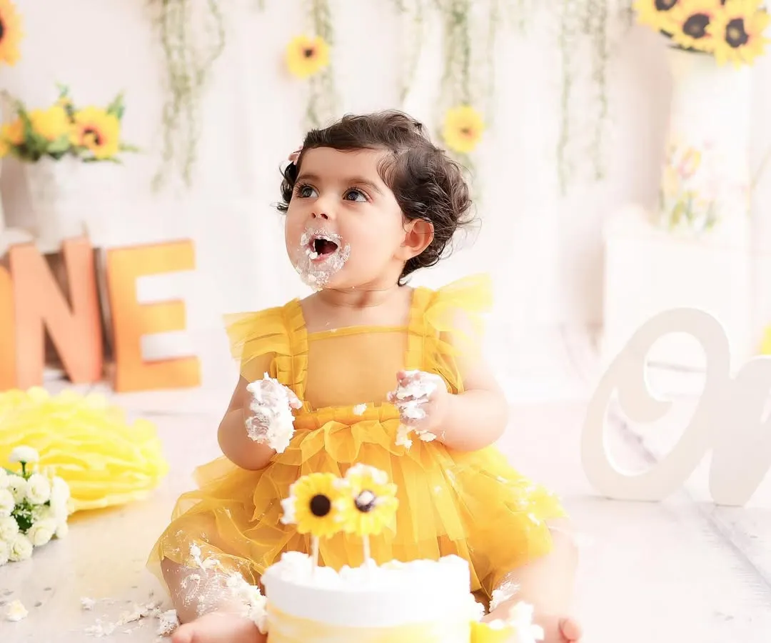 Nothing says "happy first birthday" like a cake smash! This little girl is having the best time with her sunflower themed cake, a perfect example of the pure, unscripted joy I love to capture.