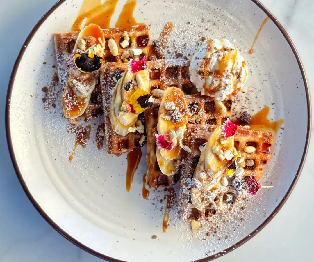 Our signature waffles are a feast for the eyes and the taste buds. Topped with fresh bananas, berries, crunchy nuts, a scoop of vanilla ice cream, and a drizzle of caramel sauce, it's the perfect treat to share or enjoy all to yourself.