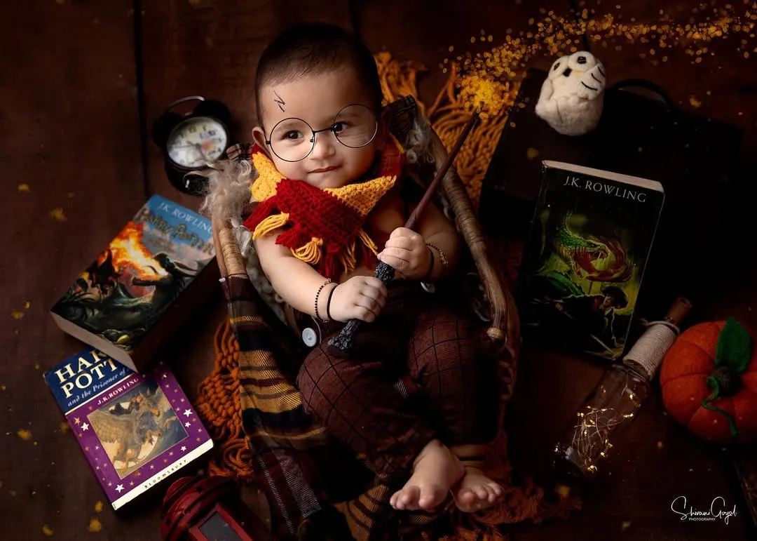 Wingardium Leviosa! This Harry Potter theme is a favorite for so many parents, and look at this little wizard. With the Gryffindor scarf, round glasses, and magic wand, this studio portrait brings a little bit of Hogwarts magic to life.