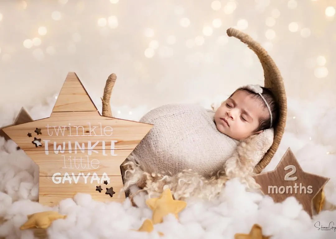 How dreamy is this "Twinkle Twinkle Little Star" setup? I love bringing your creative ideas to life. Here, little Gavyaa is sleeping peacefully on a moon prop, surrounded by fluffy clouds and stars.