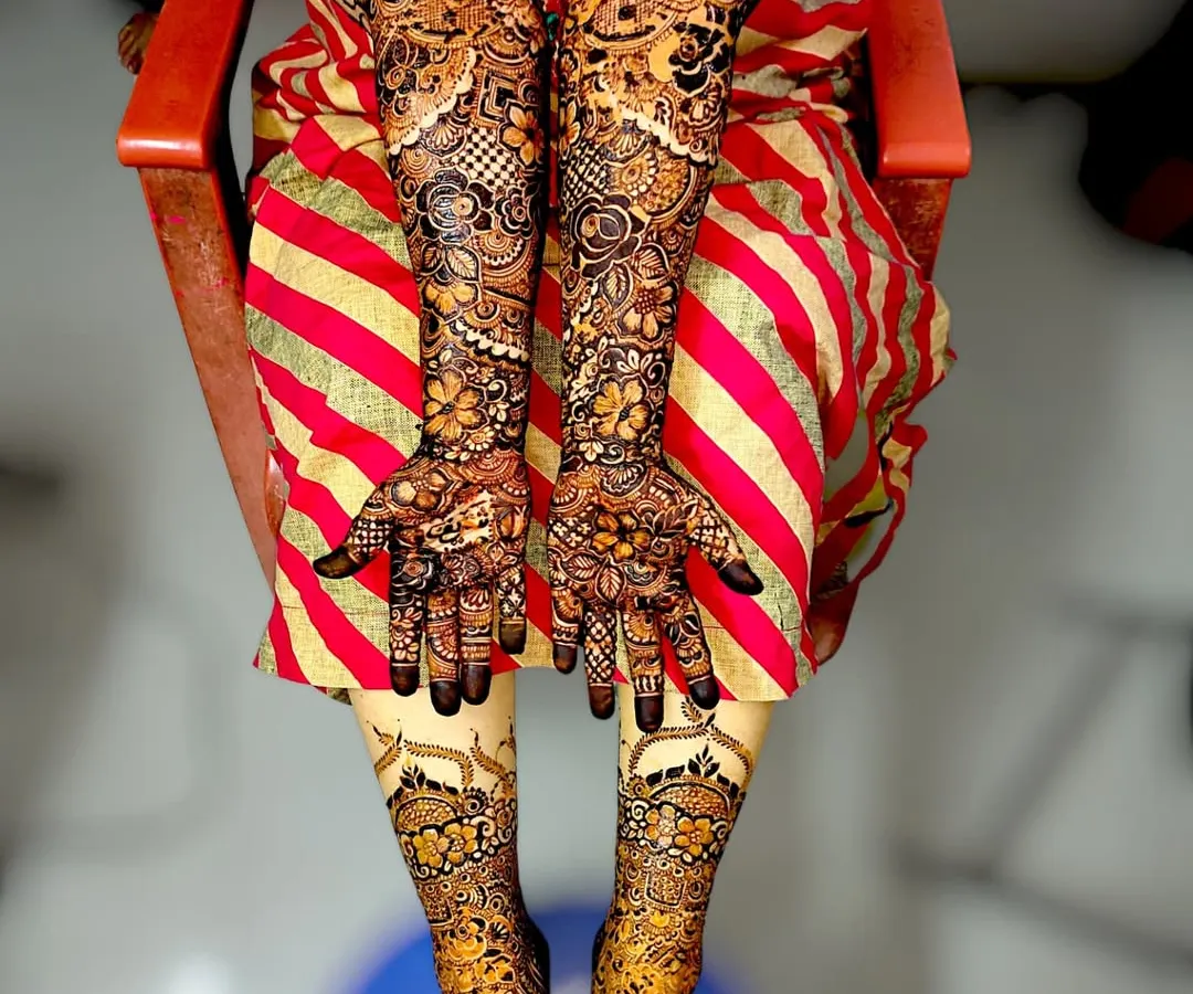 A complete bridal mehndi package. I create stunning, coordinated designs for both hands and feet, ensuring a breathtaking look for your wedding day. This design features intricate floral and paisley patterns from fingertips to elbows and across the feet.