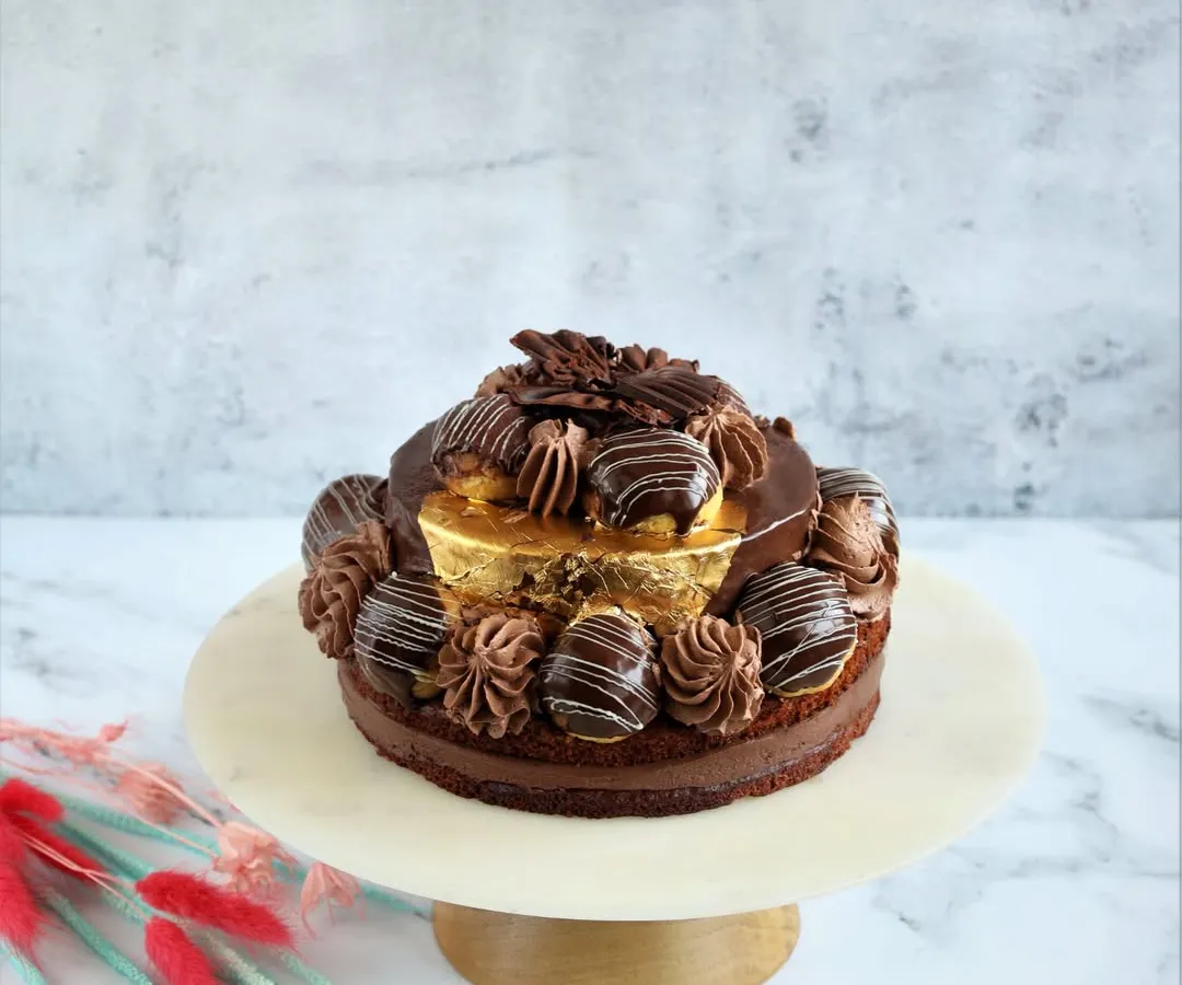 Indulge in the Desire 3 Cake. We've reconstructed this recipe for those who prefer their cakes less sweet. It features rich Saint Domingue dark couverture chocolate, a delicate chocolate dacquoise, and is garnished with 99% pure gold varak for a touch of luxury.