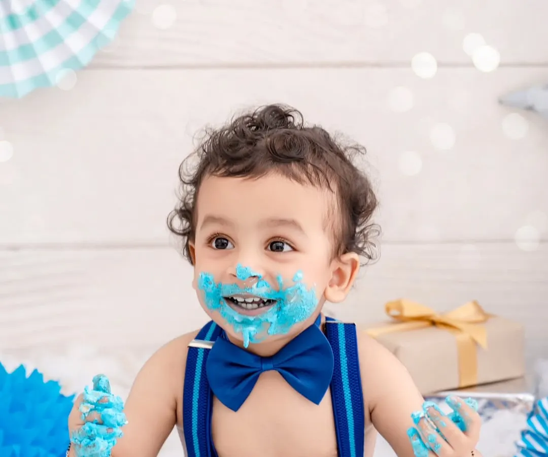 Nothing beats the pure joy of a first birthday cake smash. This little boy, with his bright blue bow tie and even brighter smile, is having the best time making a happy mess. These sessions are all about capturing that uninhibited, playful spirit.