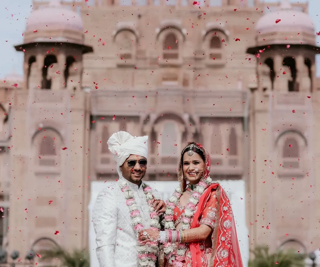 A moment of pure celebration. We live for these unscripted showers of joy, capturing the energy of your big day as you stand together against the magnificent backdrop of the Laxmi Niwas Palace.