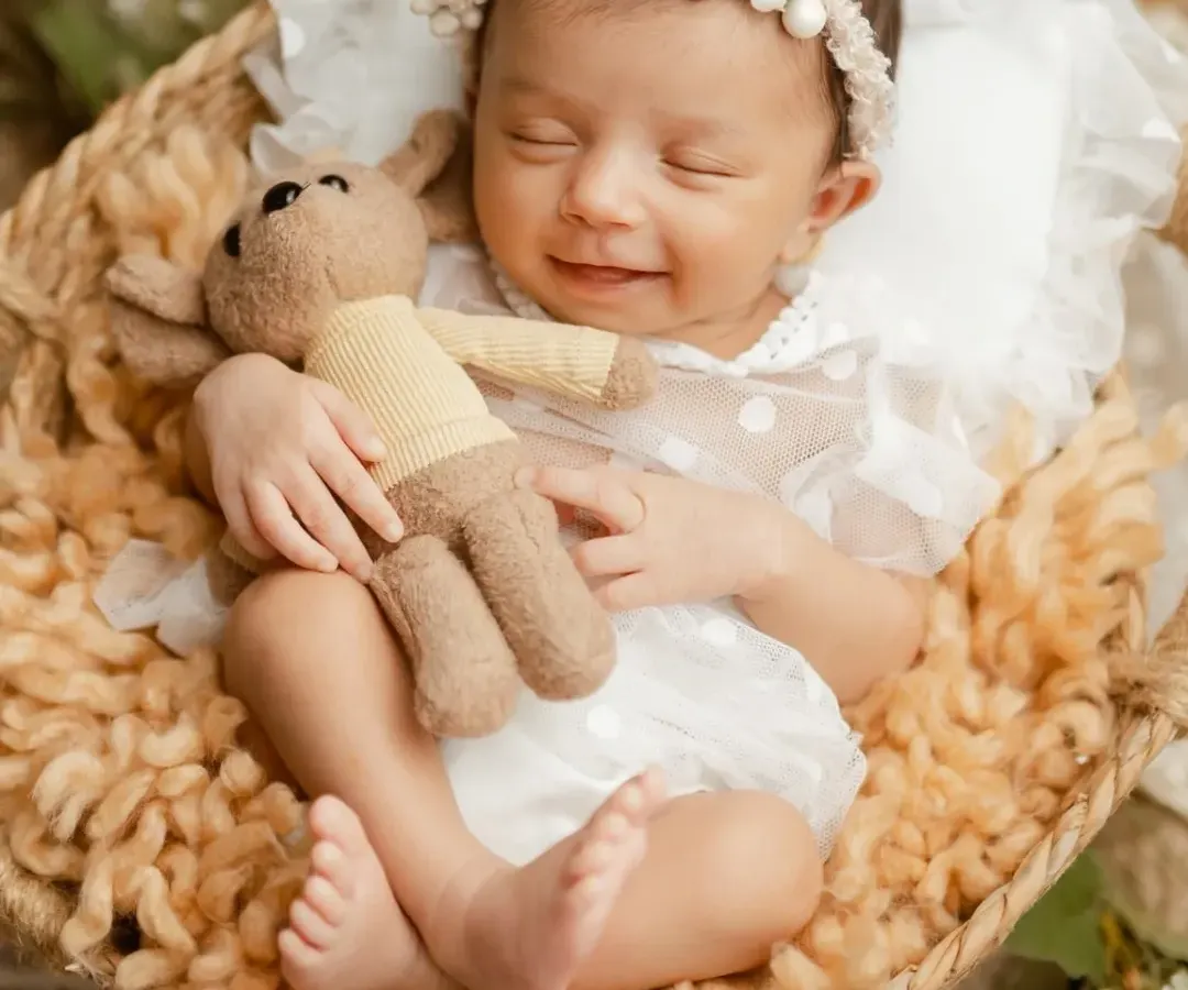 There is nothing more peaceful than a sleeping newborn. This little one gave us the sweetest smile while dreaming, a precious moment from one of our classic newborn photography sessions.