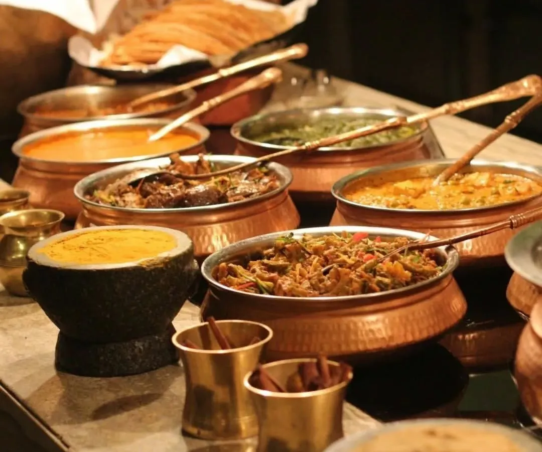 I believe presentation is just as important as taste. Here is a glimpse of a traditional Indian feast served in authentic copper and stone bowls, adding a touch of elegance and heritage to your event's dining experience.