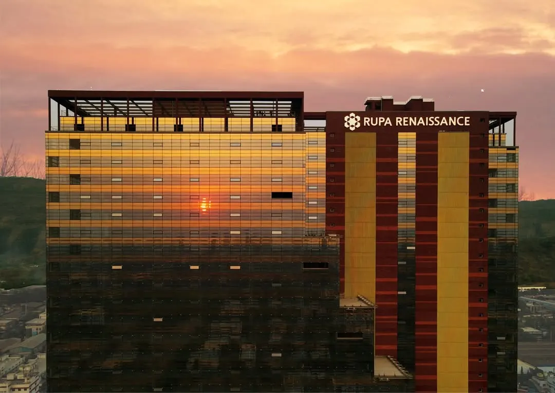 The Rupa Renaissance IT park in Navi Mumbai is captured here at sunset, with its distinctive facade reflecting the sky. This project exemplifies our focus on sustainable design, utilizing solar energy and optimal building orientation to create an energy-efficient commercial space.