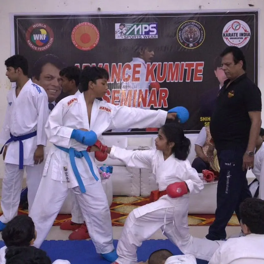 Learning from the masters is key. In this shot from our Advanced Kumite Seminar, legendary instructor Hanshi Bharat Sharma personally observes and guides young students during a sparring session, ensuring proper form and technique.