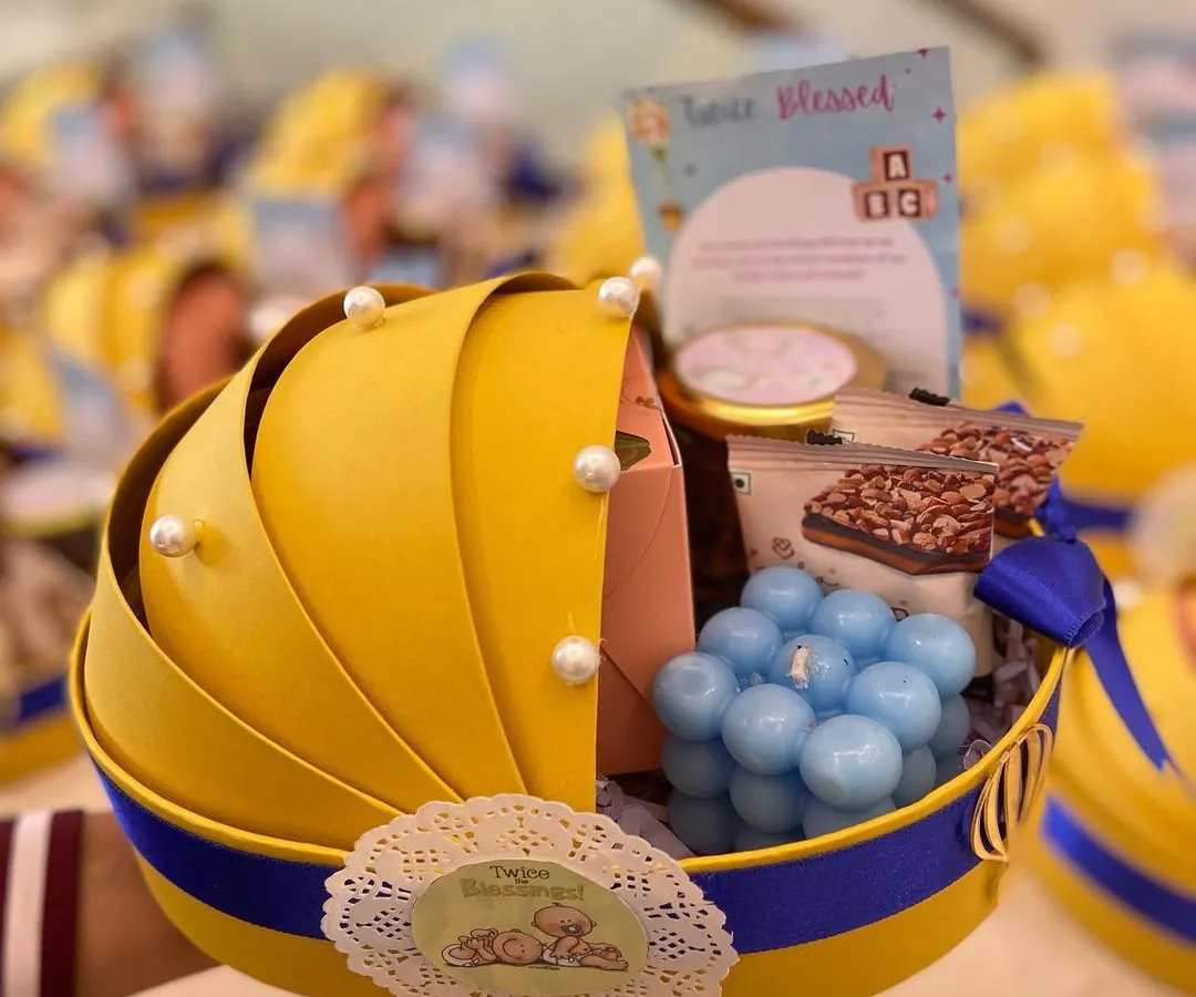 Announcing the arrival of a little one with our adorable baby cradle hamper. This uniquely shaped yellow and blue basket is filled with goodies like a bubble candle and sweet treats, making it a memorable baby announcement gift.