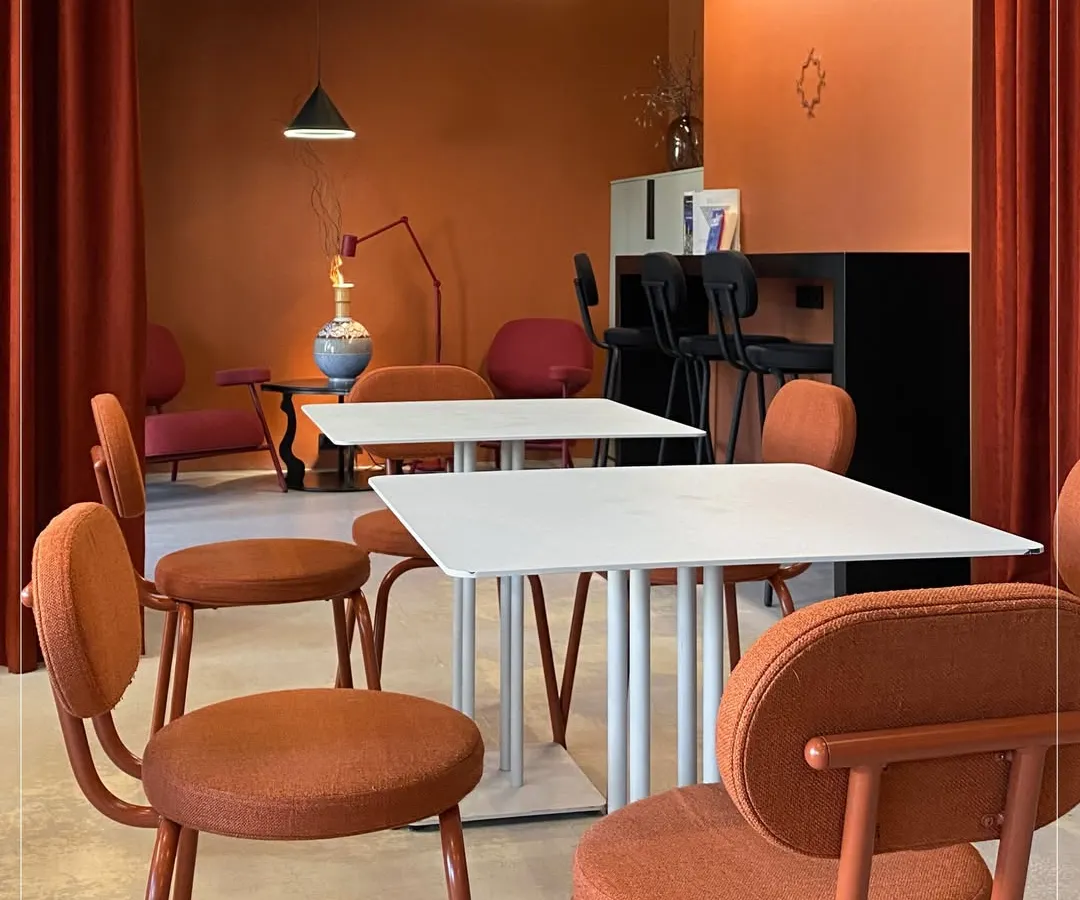 This warm and inviting cafe interior uses a terracotta color palette and modern furniture to create a memorable, "Instagram-worthy" customer experience. We focus on designing commercial spaces that are both aesthetic and functional.