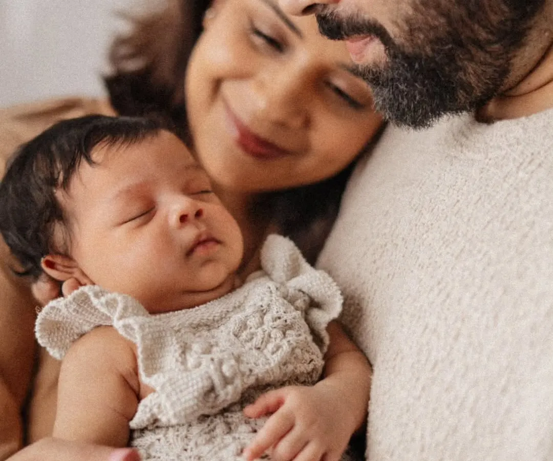 The quiet, powerful love of new parents. This intimate close-up captures a mother and father cherishing their sleeping newborn, showcasing the soft, emotional style of my newborn family portraits.