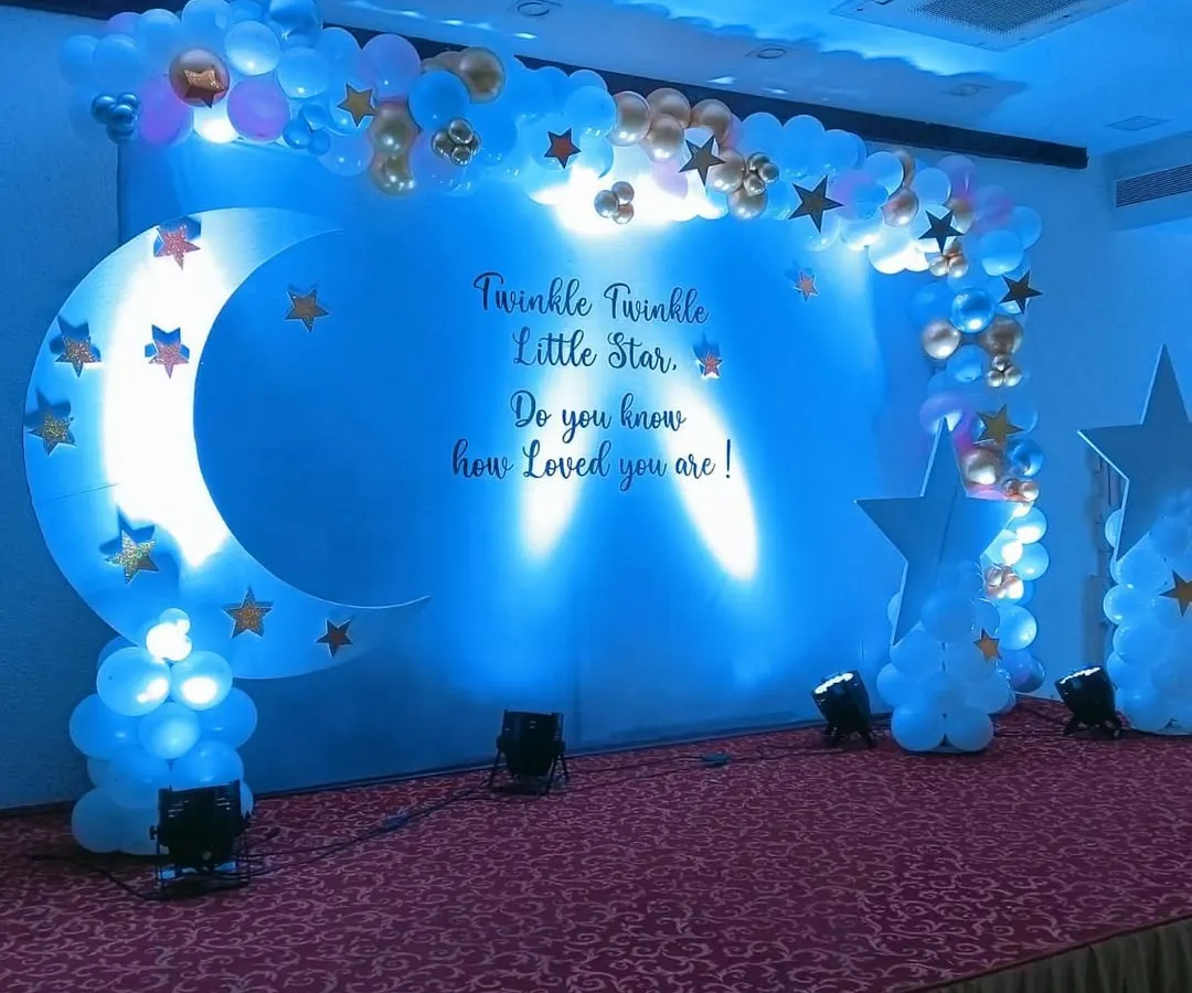 For a magical celebration, we designed this "Twinkle Twinkle Little Star" baby shower stage. The deep blue lighting, crescent moon prop, and cloud-like balloon arrangements create a dreamy atmosphere that guests love.