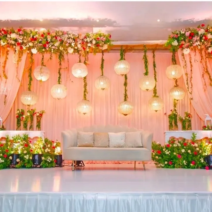 For a touch of modern romance, I design stages with soft lighting from hanging lanterns, lush floral arrangements, and contemporary seating, ensuring a picture-perfect setting for your wedding reception.