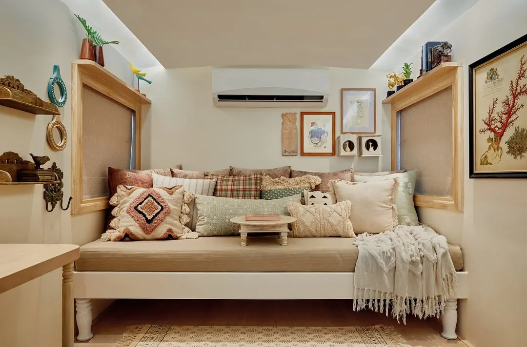 In a space of less than 80 sq. ft., creating a true sanctuary to unwind is my primary goal. This cozy daybed, which converts into a full bed for naps, is the heart of the lounge area. I layered multiple textures and prints with the cushions to add warmth and character, while an upcycled bajot serves as a versatile coffee table, making this nook both comfortable and practical.