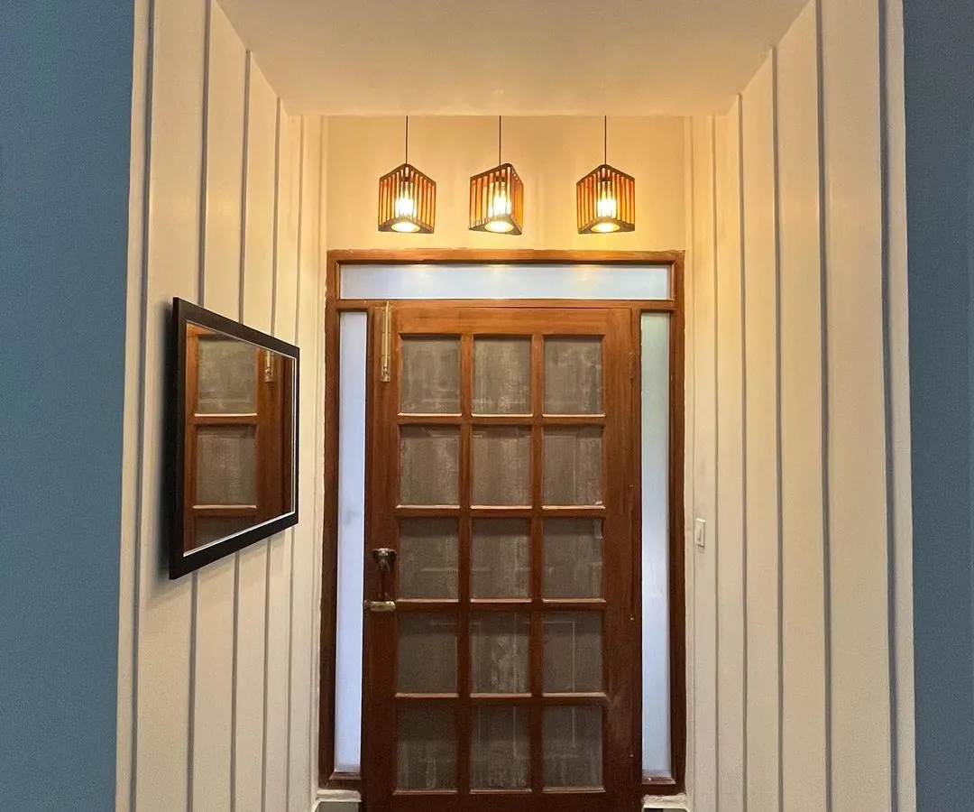 I believe a home's entrance should make a timeless first impression. Here, I transformed a simple entryway with classic checkerboard flooring, custom wall paneling, and a beautiful wooden door, creating a passage that is both elegant and welcoming.
