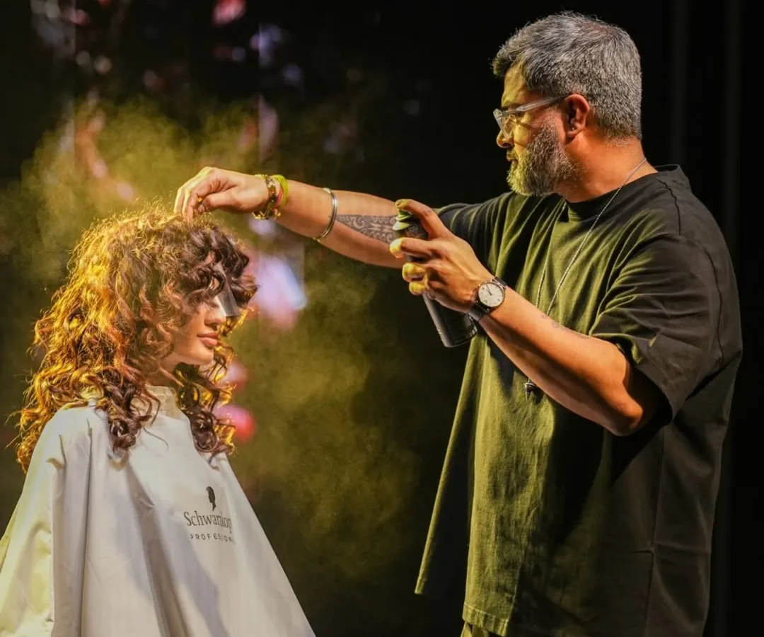 In the zone, adding the final touches on stage. This shot captures the energy of a live demonstration, where I use products like hairspray to lock in the texture and volume of these defined curls for the Schwarzkopf Lived-In Show.