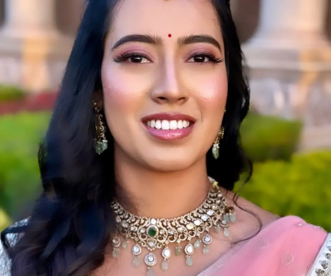This is the beautiful Keerthi, glowing for her reception. I aimed for a fresh and luminous party makeup look, with soft pink tones on the eyes and lips to match her elegant lehenga, ensuring she looked and felt amazing all evening.