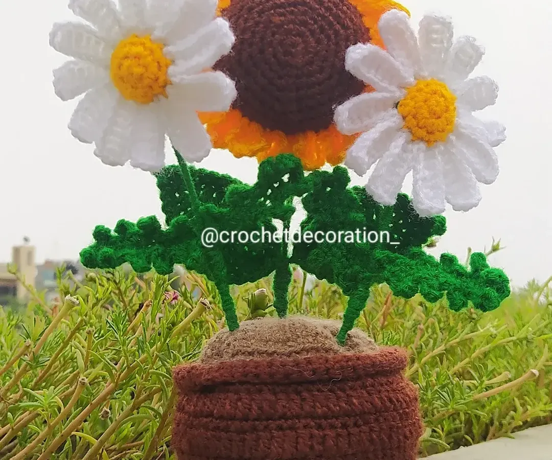 This custom potted arrangement combines a cheerful crochet sunflower with two delicate white daisies. It shows how we can mix and match different flowers in a single pot to create a unique piece for your desk or home.