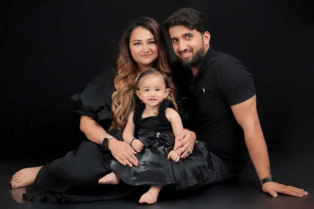 Our classic and dramatic portrait style uses a solid black backdrop to create a striking, intimate feel. By eliminating distractions, the focus is entirely on the family's bond. The coordinated all-black outfits enhance the timeless and elegant mood of this family photo.