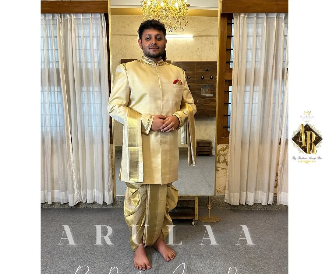 This is the classic South Indian groom's 'Muhurtam' look, made with pure silk. I designed this custom Jodhpuri-style kurta and 'kacche' (dhoti) to feel both traditional and elegant. The focus was on subtle, clean embroidery on the collar and cuffs, paired with a beautiful 'shalya' (shawl) with pure zari for that perfect ceremonial finish.