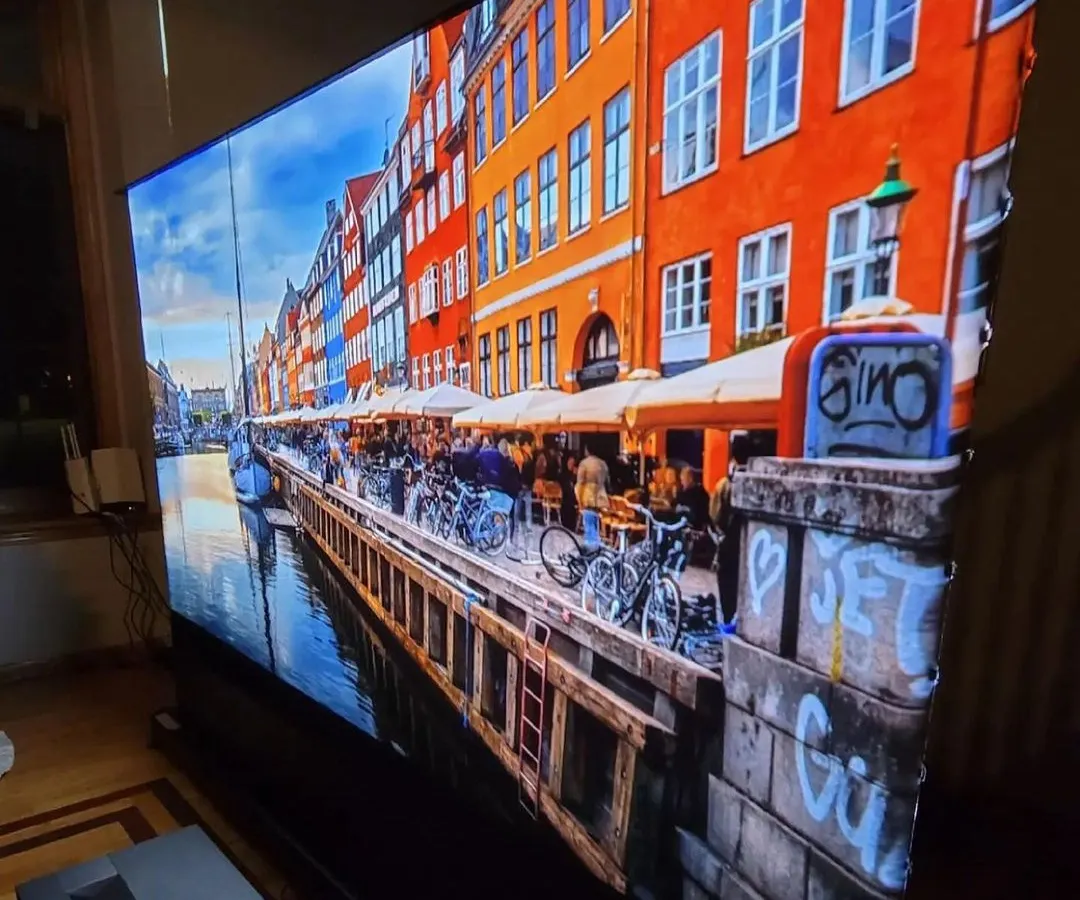 For living rooms and brighter spaces, we install ultra-short-throw (UST) projectors paired with ambient light rejecting (ALR) screens. This setup delivers a massive, vibrant 4K picture with excellent contrast and color, even without having to turn off all the lights.