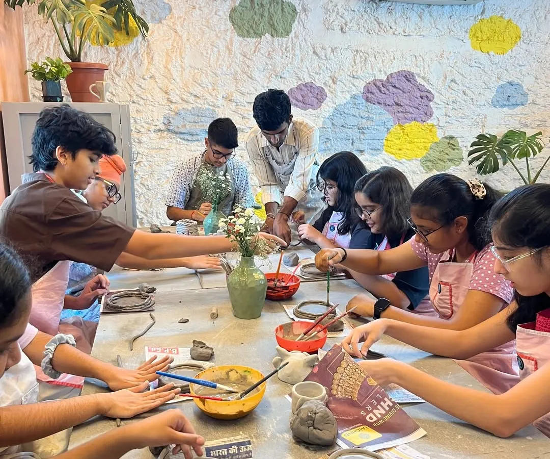 Our studio is always buzzing with creative energy, especially during our kids' workshops. Here, a group of young artists are busy with a hand-building project, each one focused on their unique creation.