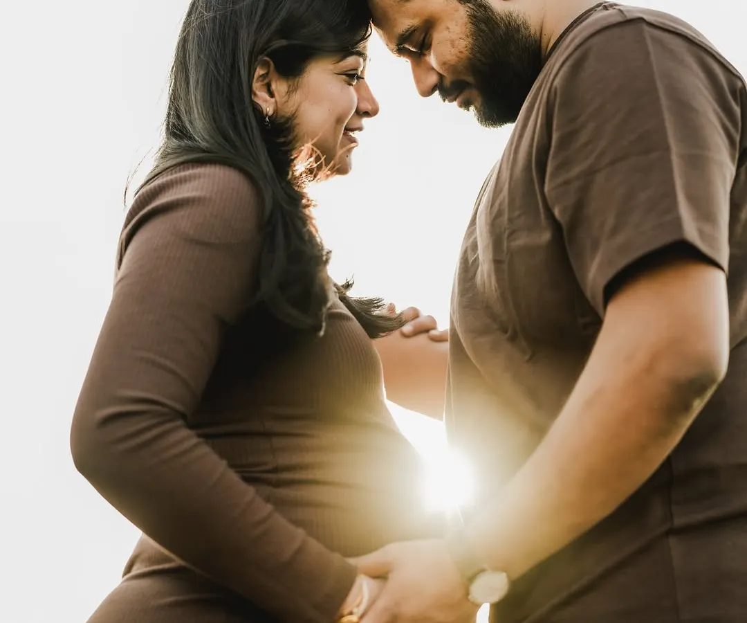 There is something truly magical about the golden hour. Here, the setting sun creates a beautiful silhouette, highlighting the deep connection between two people on the verge of parenthood. It's a quiet, intimate portrait that speaks volumes about their shared journey.