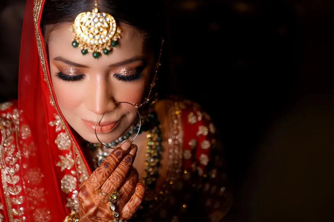 A bride's quiet moment of reflection before she walks down the aisle. I focus on capturing the delicate details, from the sparkle in her eyes to the intricate henna, telling a story of anticipation and beauty.