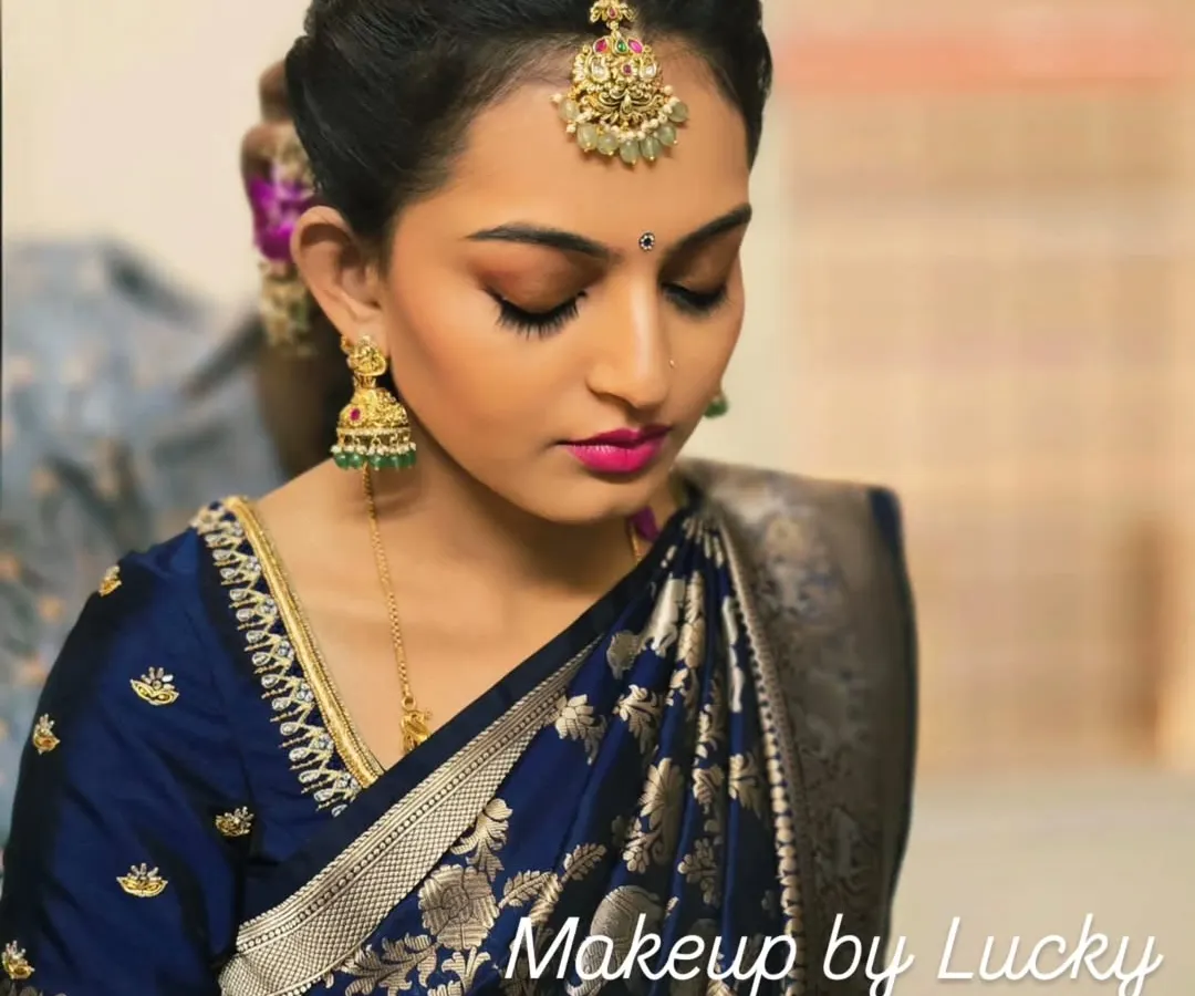 This is the classic South Indian festive look I created for a client's family ceremony. The focus is on flawless skin, defined eyes with a gold shimmer, and a bold pink lip to complement her royal blue silk saree.