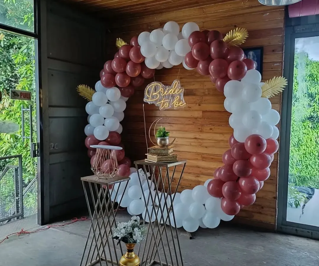 This full circular balloon arch is one of our most requested designs for bachelorette parties. The rich burgundy and white balloons, paired with a custom 'Bride to be' neon sign, create a sophisticated and celebratory focal point, perfect for any indoor or covered venue.