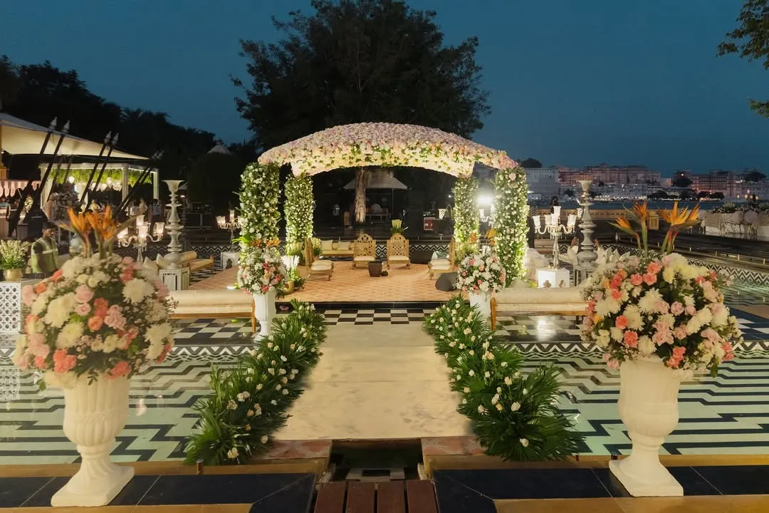 I transform royal palace courtyards into dreamlike wedding venues. This stunning floral mandap at The Leela Palace Udaipur, set against the water, showcases my ability to blend natural beauty with opulent design for a destination wedding.
