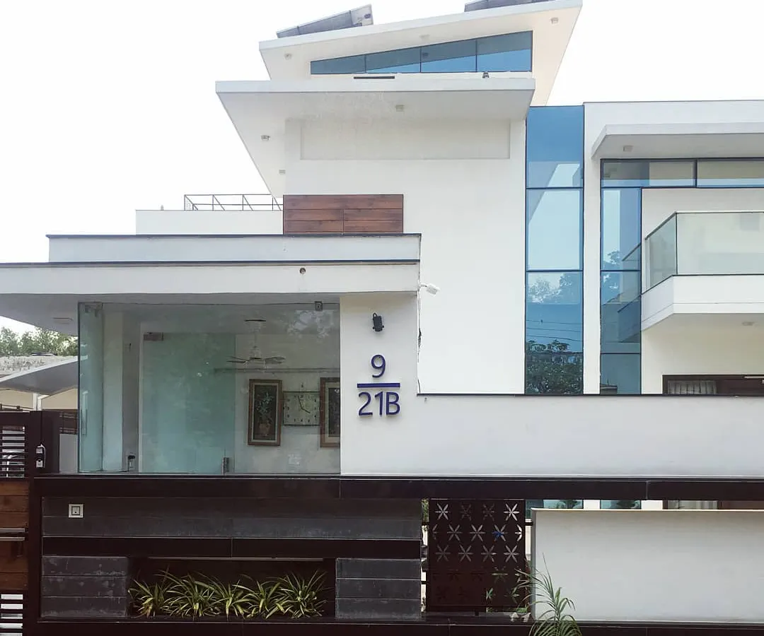 The clean, contemporary facade of Villa 9/21B in Faridabad. This project highlights our expertise in modern villa architecture, using a minimalist palette of white render, glass, and wood accents to create a home that is both striking and serene.