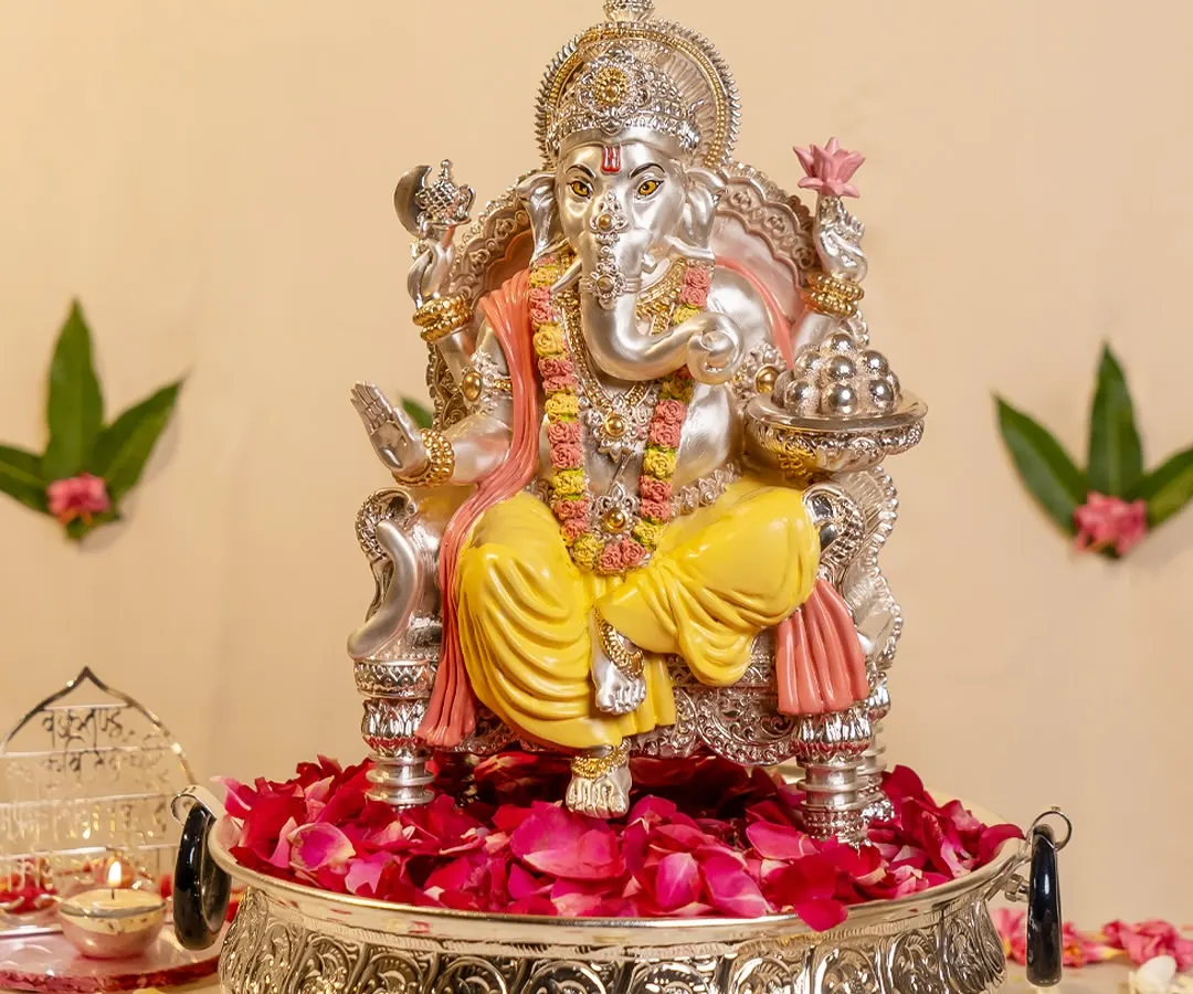 I believe in bringing divinity into the home with grace. This magnificent silver-plated Lord Ganesha idol, seated on a bed of delicate rose petals, radiates peace and regal blessings, making it a powerful centerpiece for your sacred space.