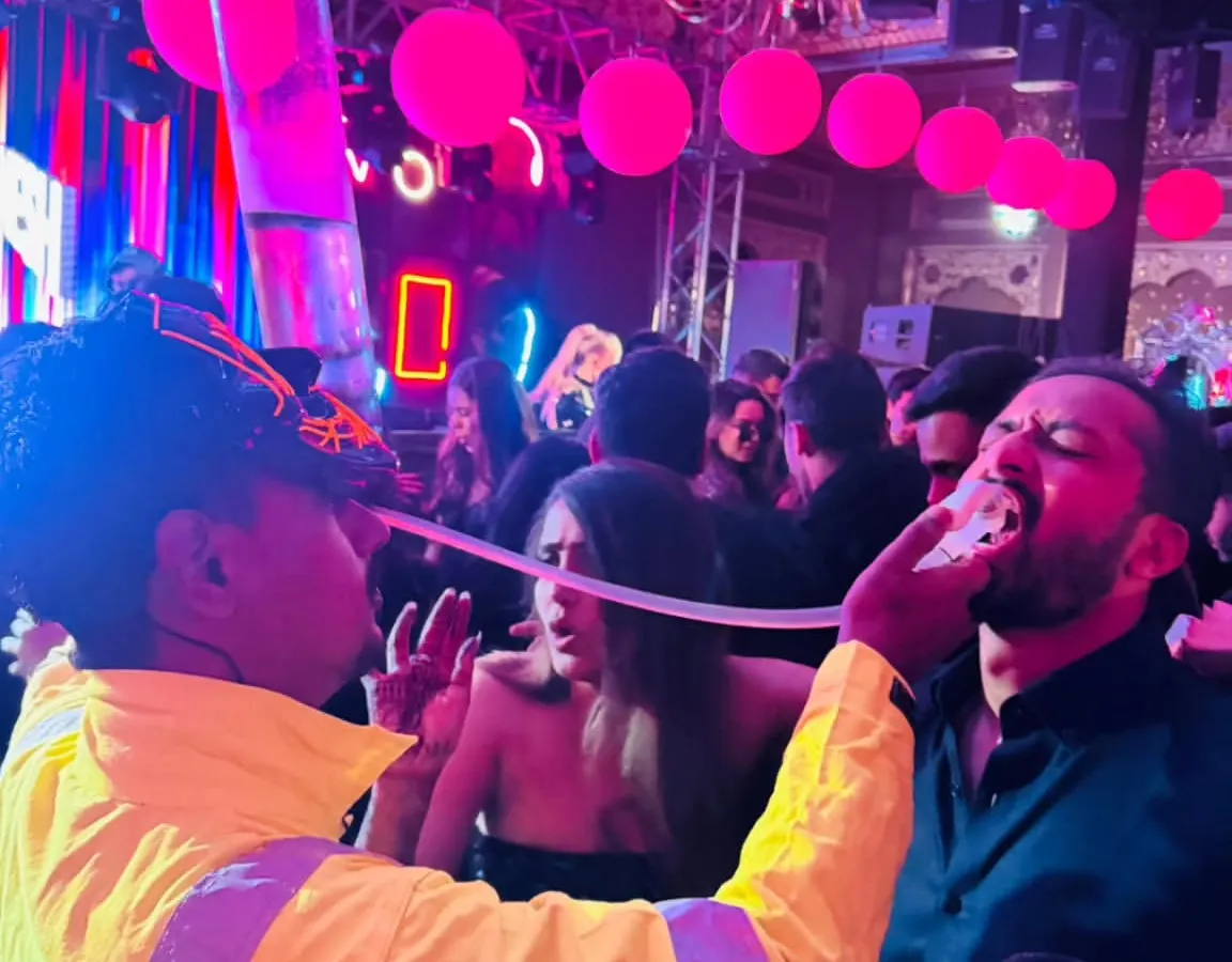 We are all about creating high-energy, interactive moments. Here, one of our bartenders uses a custom shot dispenser to bring the party directly to the guests, ensuring the fun never stops.