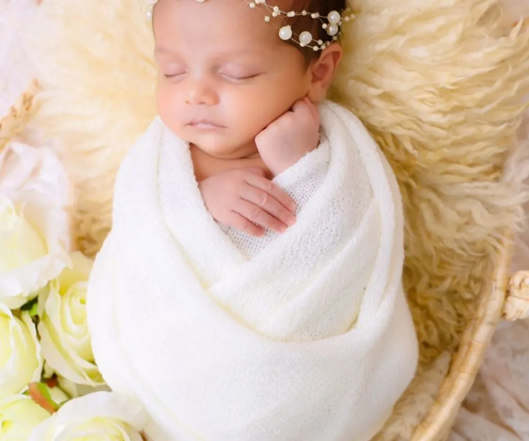 A classic portrait of newborn serenity. We gently swaddle your baby, creating a sense of security and peace that allows us to capture their perfect, sleeping form in a simple and beautiful way.