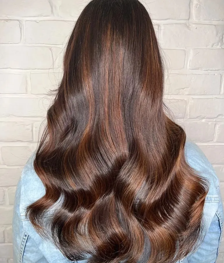 A beautiful example of a copper brown and golden balayage. The colors are blended to create a rich, dimensional look with lots of shine and movement.