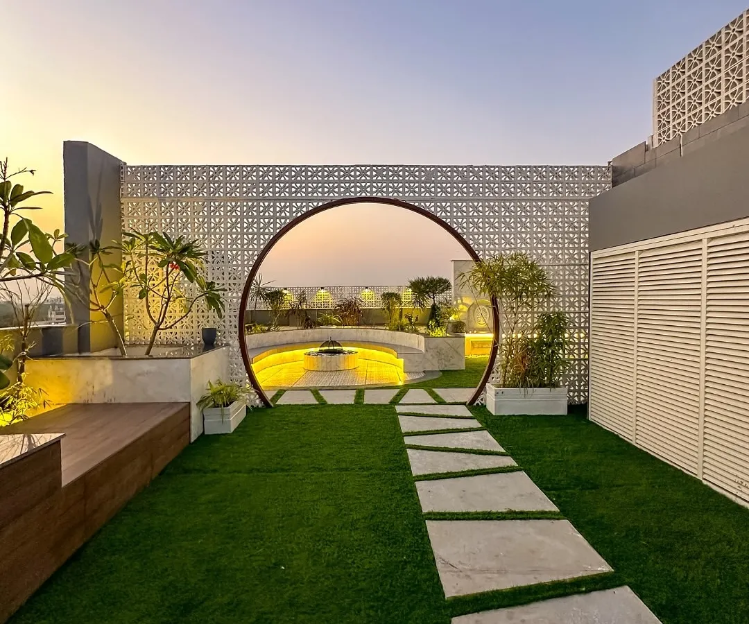 We love making a grand entrance. This custom moon gate, set against a modern jaali wall, creates a stunning entryway to a hidden garden, perfectly framing the sunset view. It’s a statement piece that adds architectural drama and a sense of discovery.