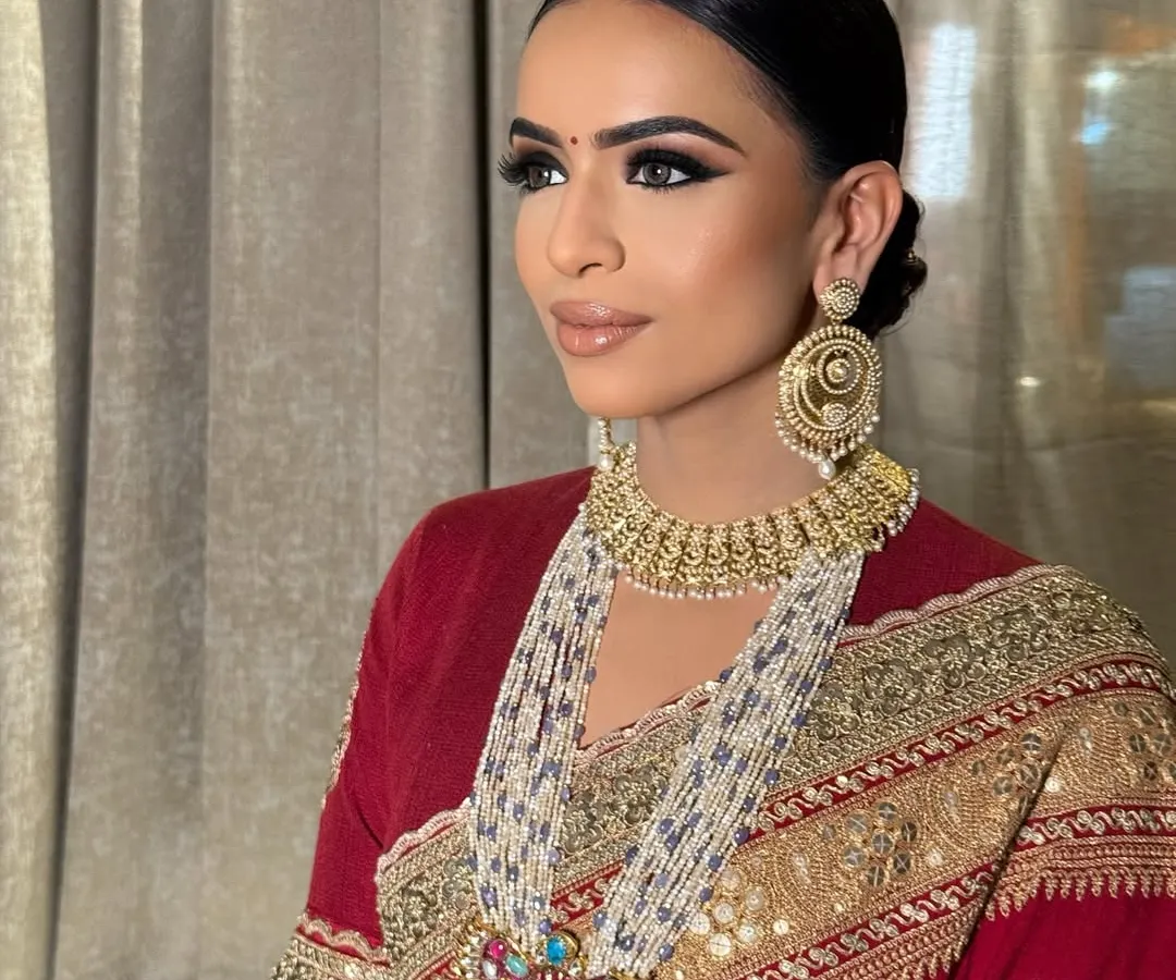 For this classic bridal look, I created a dramatic winged eye to complement the traditional red Sabyasachi saree. The skin is kept luminous with a neutral lip, ensuring the focus remains on her expressive eyes and the intricate details of her outfit.