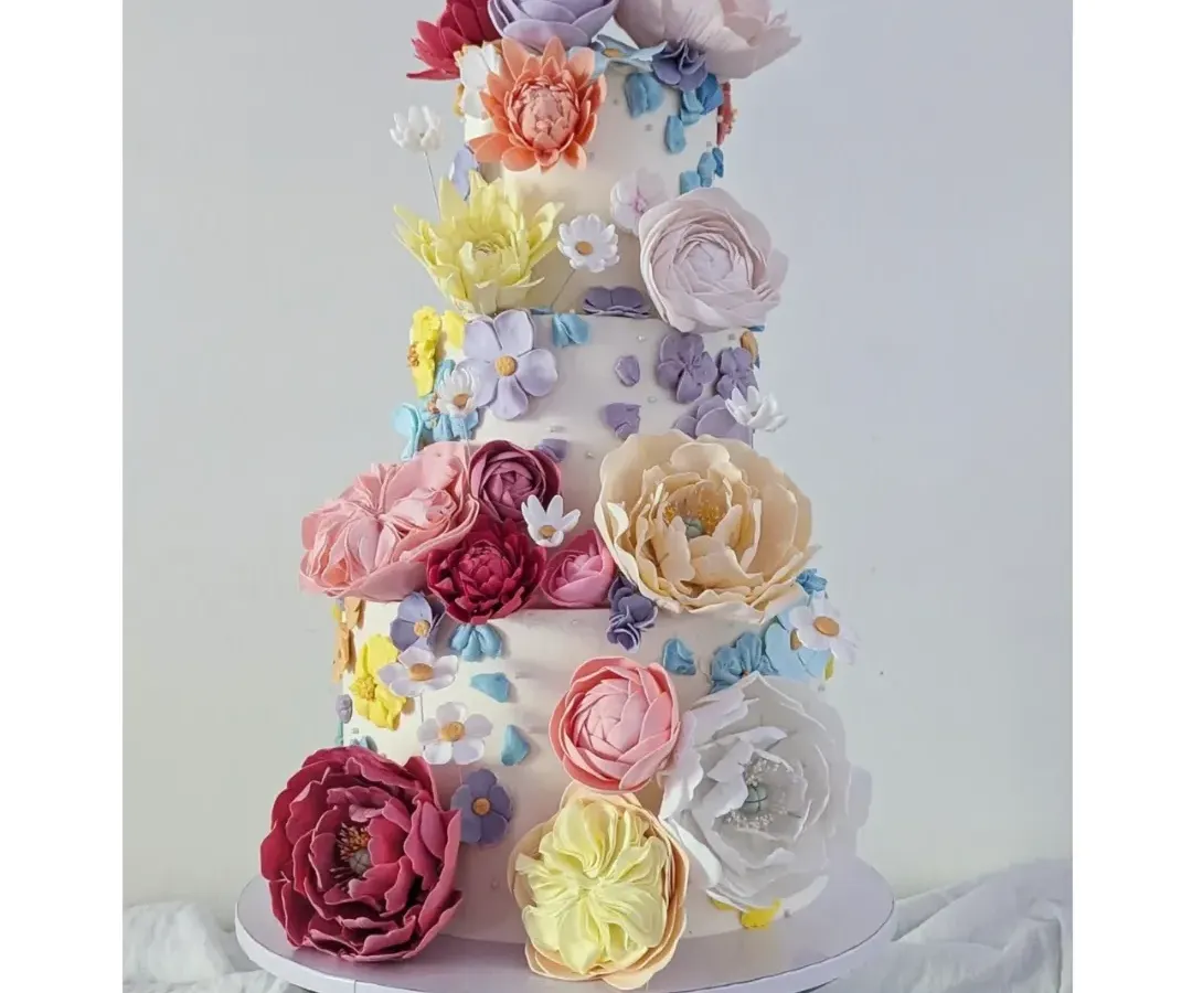 For this wedding cake, I wanted to create the feeling of a spring garden in full bloom. It’s covered in a mix of handcrafted sugar flowers and delicate buttercream flowers, making it a joyful and spectacular centerpiece for a truly special day.