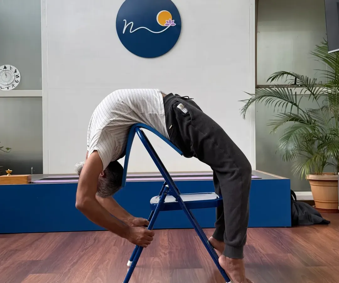 Using a chair for a deep backbend like this variation of Urdhva Dhanurasana allows us to safely explore the spine's potential. Props are not a crutch but a tool for deeper understanding and alignment in our practice.