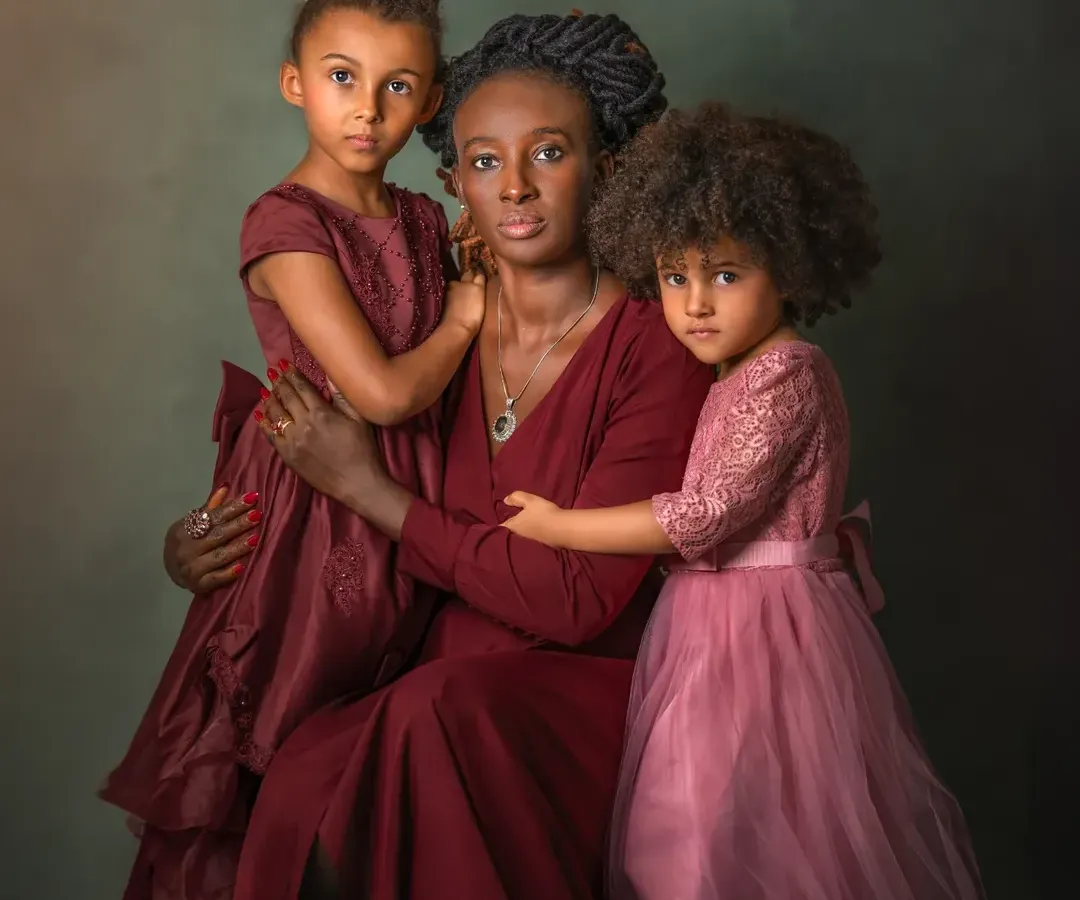 Motherhood is a masterpiece of emotions, and this portrait aims to capture its beautiful complexity. Here, a mother's protective embrace and her daughters' trusting gazes create a powerful, loving tableau reminiscent of a classic painting. It’s a celebration of the unbreakable bond between a mother and her children.