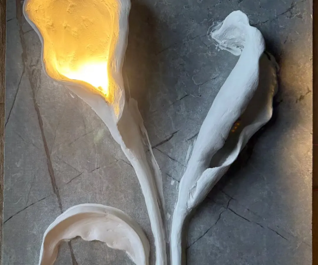 Here, I combined sculpture with function. This 3D floral wall art features hand-sculpted calla lilies on a stone-textured base, with integrated lighting that casts a warm, elegant glow, turning the wall into a statement piece.
