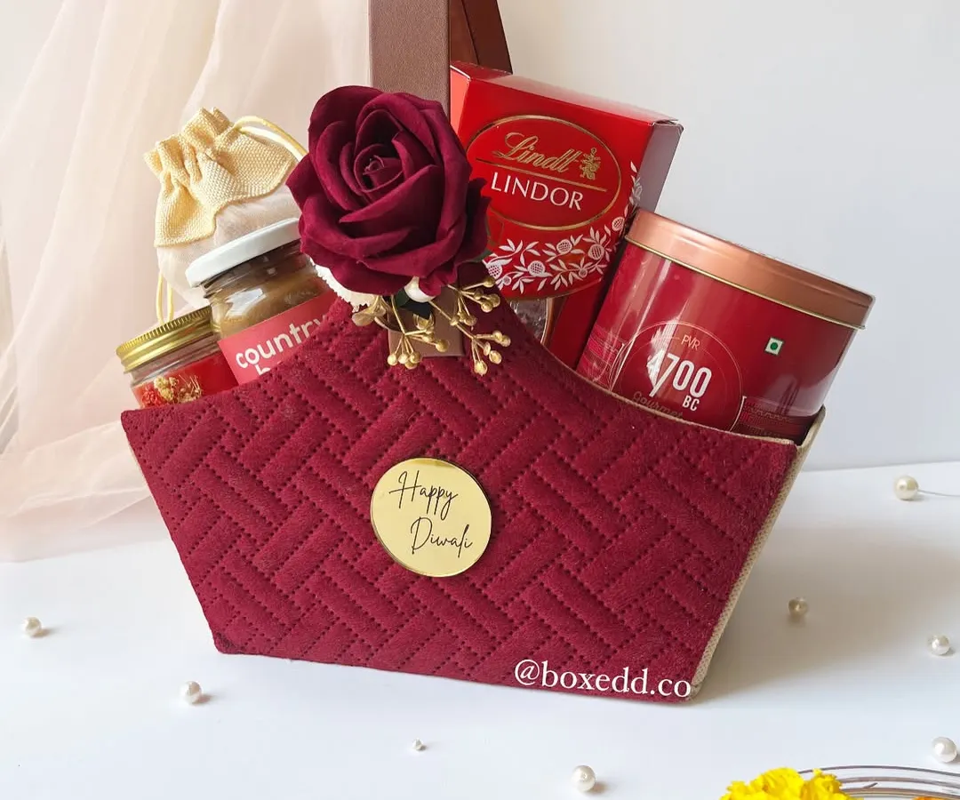 This is one of my signature Diwali hampers. I love combining rich textures and a festive color palette, like this quilted maroon basket, filled with gourmet treats and luxury items to make the celebration feel extra special.
