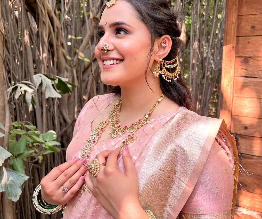 This is the radiant smile I love to see. For this beautiful Maharashtrian bride, we chose a soft, rosy makeup look to complement her pink Paithani saree. The focus was on creating a luminous, skin-like base that glowed in the natural light, making her feel absolutely unforgettable on her special day.