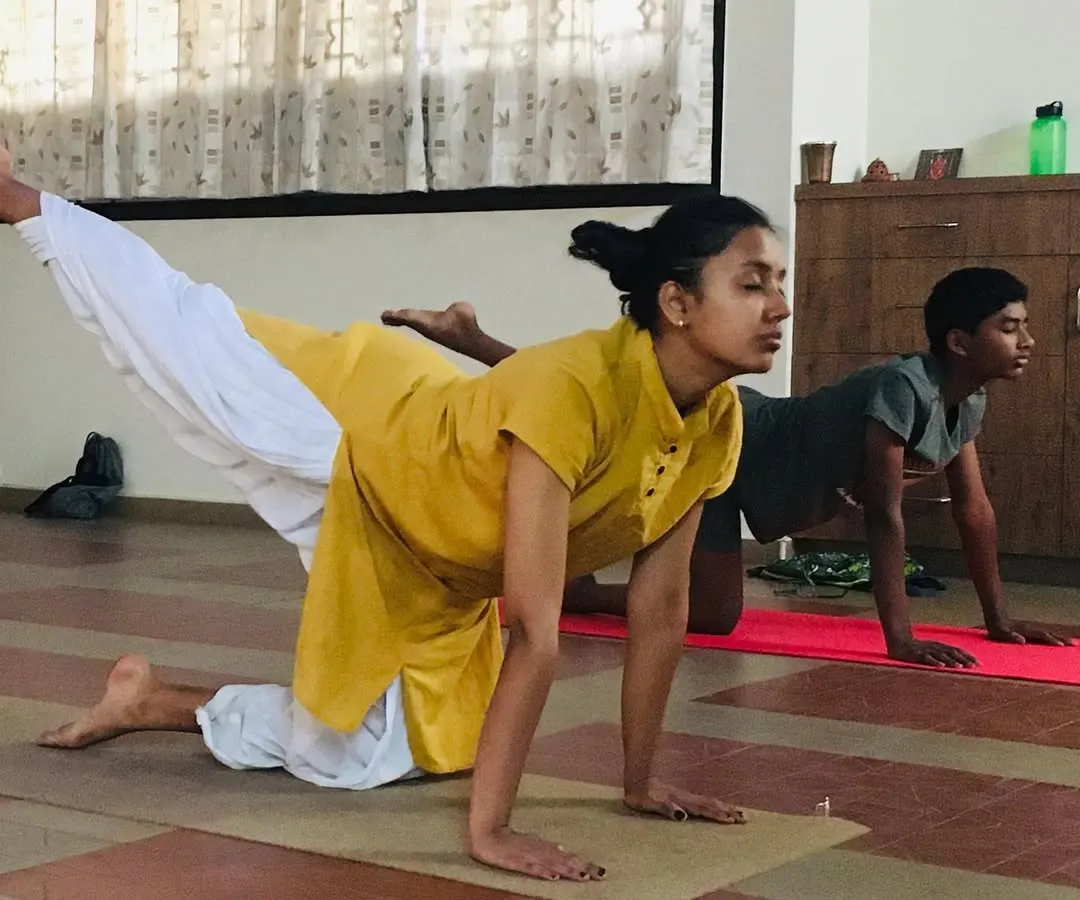 Teaching is a partnership. In this photo, I am guiding a young student through a posture during a kids' yoga session. I ensure each child receives personal attention to help them with alignment and to make sure they are practicing safely and effectively.