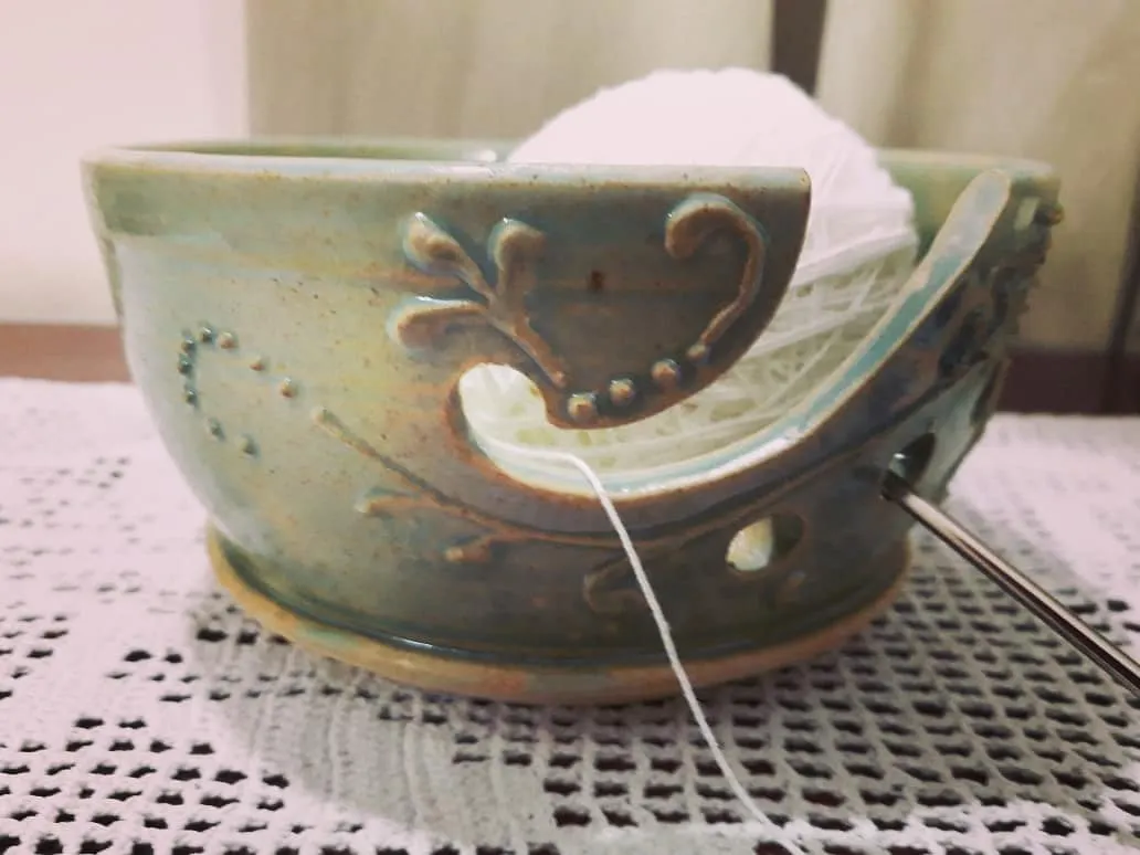 A happy knitter using their custom-made yarn bowl. I designed this piece with a special swirl to guide the yarn and decorative carvings, making it both a practical tool and a beautiful object for their craft corner.